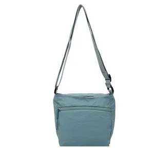 Light blue nylon crossbody bag with adjustable strap and front zipper pocket for casual style