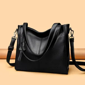 Detail of black pebbled leather texture with silver hardware and embossed VAGELAISHI logo
