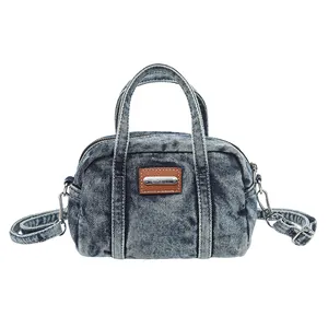 Blaue Denim-Boston-Tasche mit braunem Lederpatch und verstellbarem Schultergurt