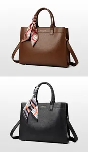 Dettaglio di borse tote in pelle martellata con foulard di seta e logo dorato raffinato