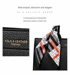 Dettaglio borsa tote in pelle nera a grana con elegante foulard in seta a motivi geometrici