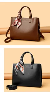 Dettaglio della borsa tote in pelle martellata con foulard e logo dorato