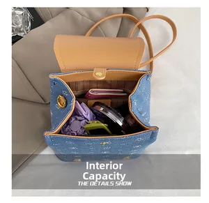 Internal capacity of blue denim backpack with brown faux leather straps and items