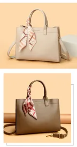 Dettaglio di borse tote in pelle beige e caffè con foulard in seta e tracolle incluse