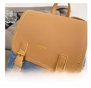 Detail showing the tan leather flap with contrast stitching and star denim fabric
