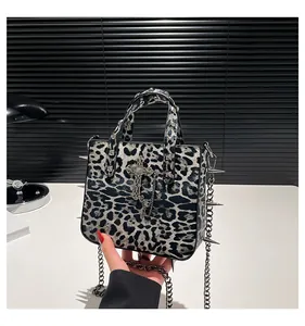 Detail of punk style leopard print tote bag with silver cross and metal spikes