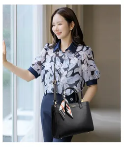 Dettaglio della borsa tote nera in pelle con motivo litchi e foulard in seta decorativo