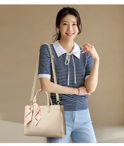 Dettaglio borsa tote beige in pelle martellata con foulard di seta e tracolla moda