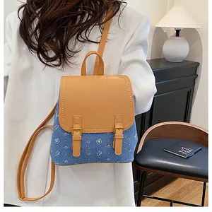 Detail view of denim and leather backpack with bear print on a female model