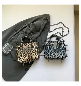 Detail of leopard print tote bags with punk metal spikes and cross metal hardware