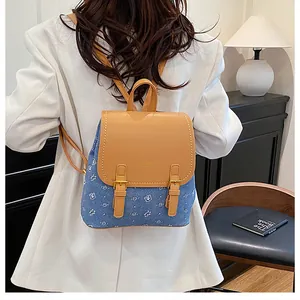 Chic blue denim and brown leather mini backpack featuring a cute white bear pattern