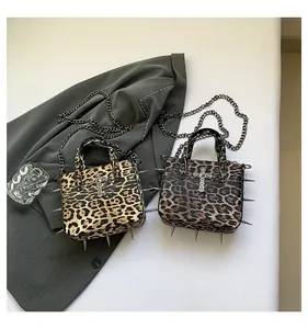 Detail of leopard print tote bags with punk rivets, metal crosses and chain straps