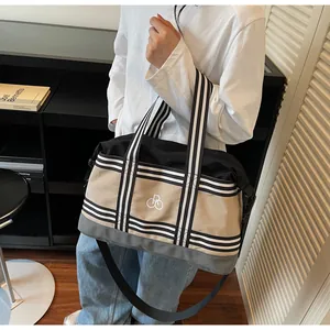 Detail view of large khaki and black patchwork travel bag with durable striped handles