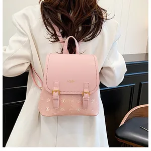 Detail view of pink PU leather backpack with gold buckles and cute bear prints on model