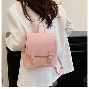 Pink mini backpack detail featuring cartoon bear prints and decorative gold buckle straps