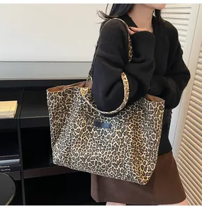 Detail shot of a large leopard print canvas tote bag with sturdy double handles for daily use