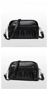 Macro shot of black pebbled leather crossbody bag with pleated details and silver zippers