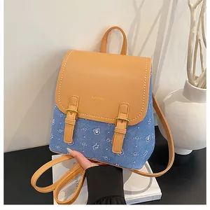 Detail showing the yellow faux leather flap and blue denim body with bear pattern