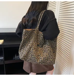 Detailed view of large capacity leopard print canvas tote bag styled on model's shoulder