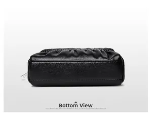 Detailed bottom view of black pebble leather shell bag with smooth stitching and pleats
