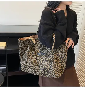 Detailed view of large leopard print canvas tote bag styled with casual fall outfit