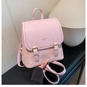Detailed view of pink leather backpack featuring bear graphics and gold buckle closures