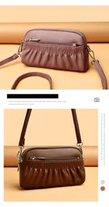 Detail of multi-zipper leather crossbody bags with vertical pleats in pink and brown