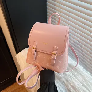 Close-up of pink backpack featuring cute cartoon bear print and gold buckle detail