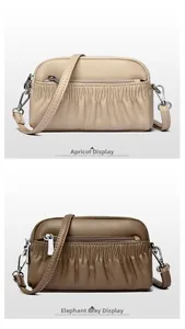 Detail view of double-layer leather shells in beige and elephant gray with pleated finish