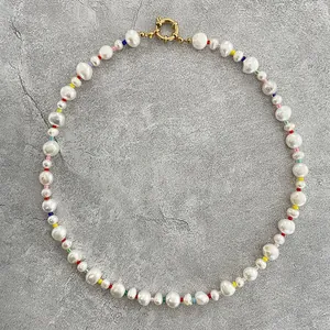 Detailed close-up of baroque pearls and vibrant multi-color beads with a gold clasp