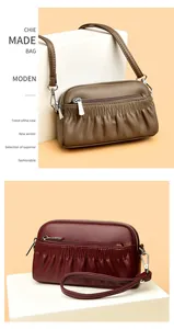 Detail of genuine leather shell bag showing ruched design and dual zipper closures