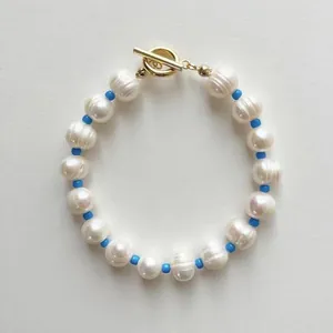 Bracelet en perles d'eau douce baroques avec perles bleues et fermoir OT doré sur blanc
