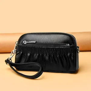 Black pleated leather shell shoulder bag with silver zippers and a wrist strap