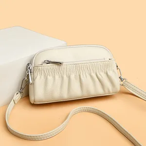 Chic beige pleated leather shell crossbody bag with double zippers and slim shoulder strap