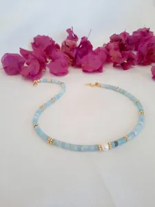 Macro shot of blue beaded necklace with central freshwater pearl and gold flower spacers