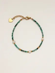 Dettaglio del bracciale con pietre naturali verdi e perle con ciondolo a cuore e chiusura