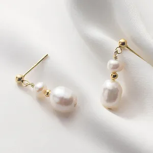 Eleganti orecchini a goccia con perle barocche naturali e dettagli dorati su seta