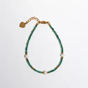 Dettaglio del bracciale con pietre naturali verdi, perle d'acqua dolce e cuore dorato