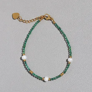 Dettaglio di perle in pietra verde e perle d'acqua dolce bianche con ciondolo a cuore d'oro