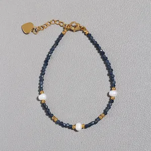Vista dettagliata del bracciale con pietre blu, perle e ciondolo a cuore dorato
