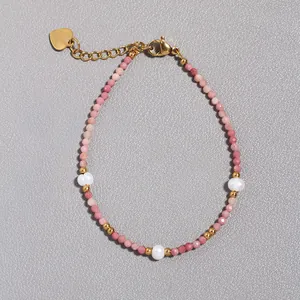 Dettaglio del bracciale con pietre naturali rosa, perle e ciondolo a cuore dorato