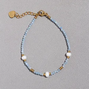 Dettaglio macro del bracciale con perle d'acqua dolce, pietre blu e ciondolo a cuore