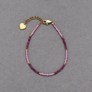 Detailed view of bohemian beaded bracelet with pink stones and gold heart charm