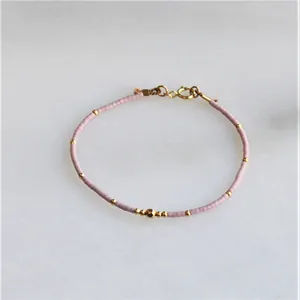 Handmade Bohemian pink beaded bracelet with elegant gold accents and adjustable lobster clasp
