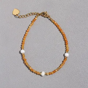 Dettaglio del bracciale con pietre naturali arancioni, perle d'acqua dolce e ciondolo a cuore