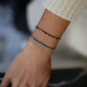Detailed close-up of Bohemian colorful beads and turquoise bracelets on a wrist