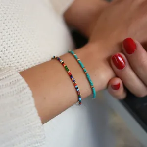 Detail of bohemian colorful seed bead and turquoise bracelets layered on a wrist