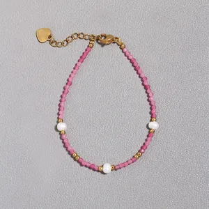 Dettaglio del bracciale con perle di cristallo rosa, perle d'acqua dolce e ciondolo a cuore