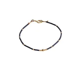 Handmade bohemian navy blue beaded bracelet with gold metal accents and spring clasp