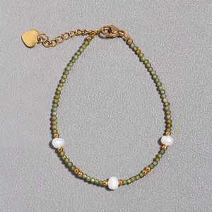Dettaglio del bracciale in pietra naturale e perla con ciondolo a cuore dorato e chiusura